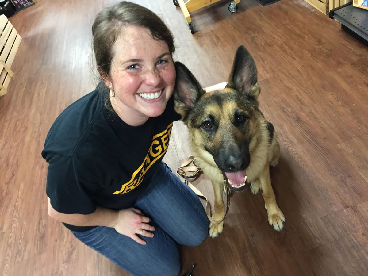 A 3D Dog client kneeling with her German Shepherd service dog